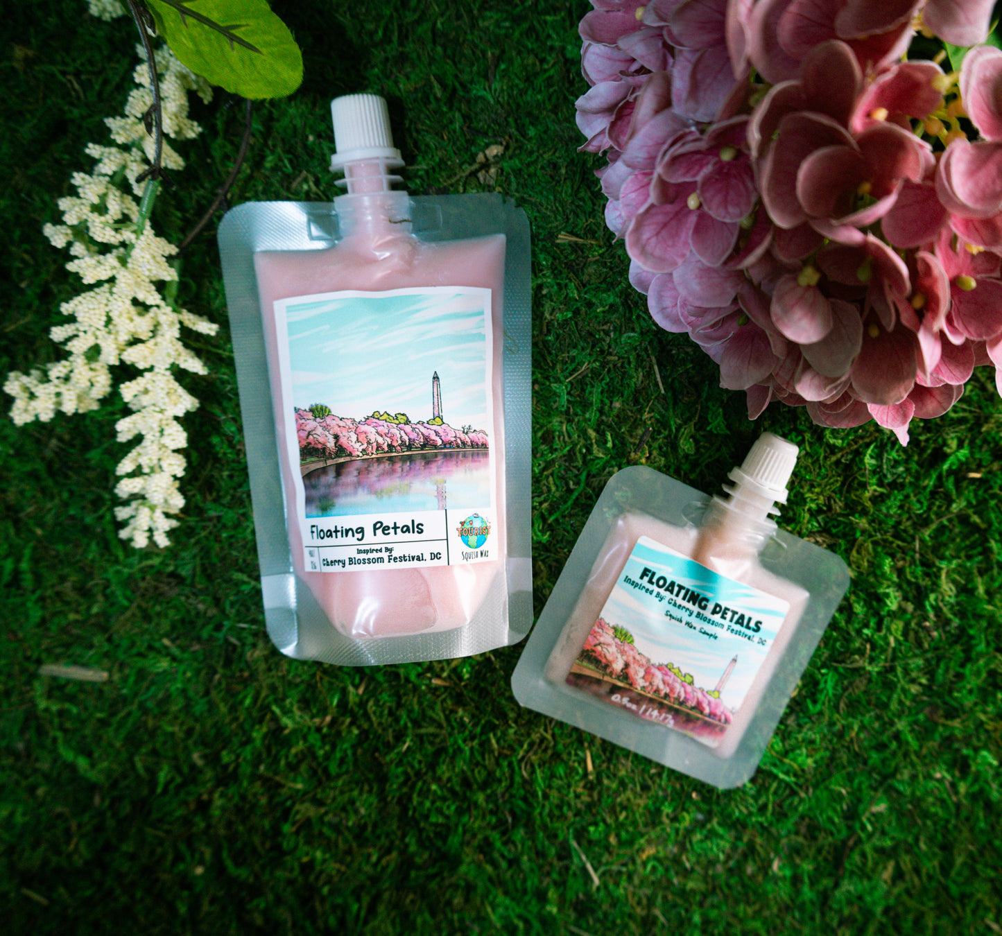 Pouches of cherry blossom-themed squeezable wax melt product with a scenic label on a white background