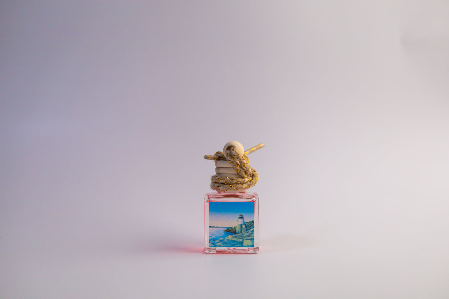 Small car freshener glass bottle themed Rhode Island in front of white background