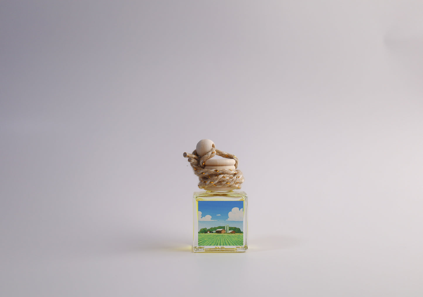 Small glass car freshener with Iowa themed artwork on white background