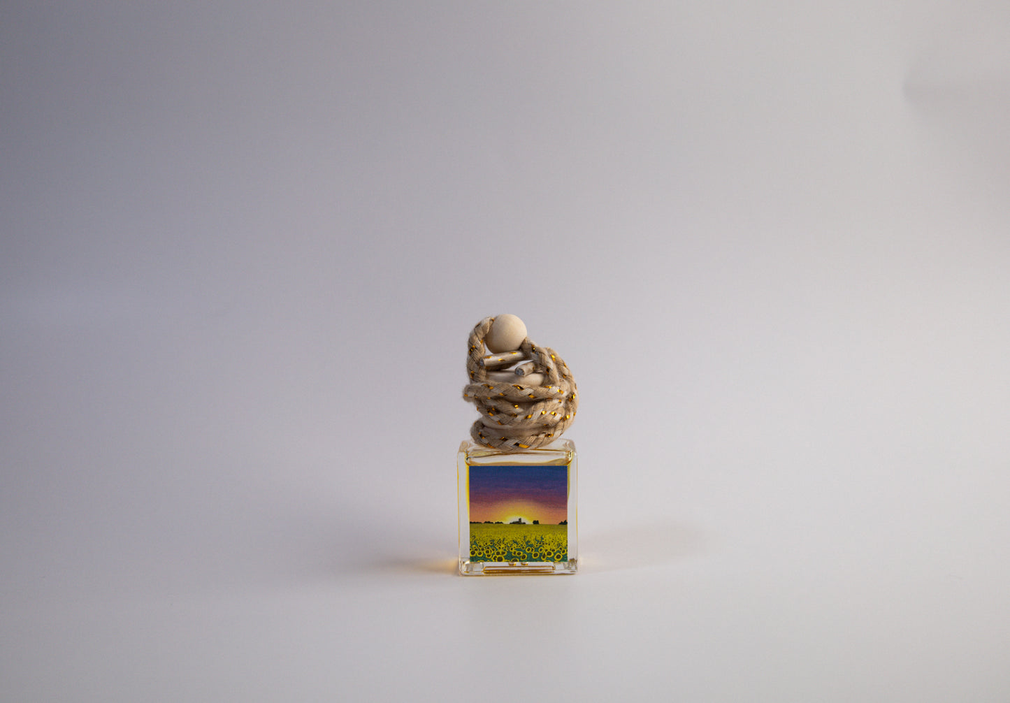 Small decorative Kansas themed car freshener in front of white background