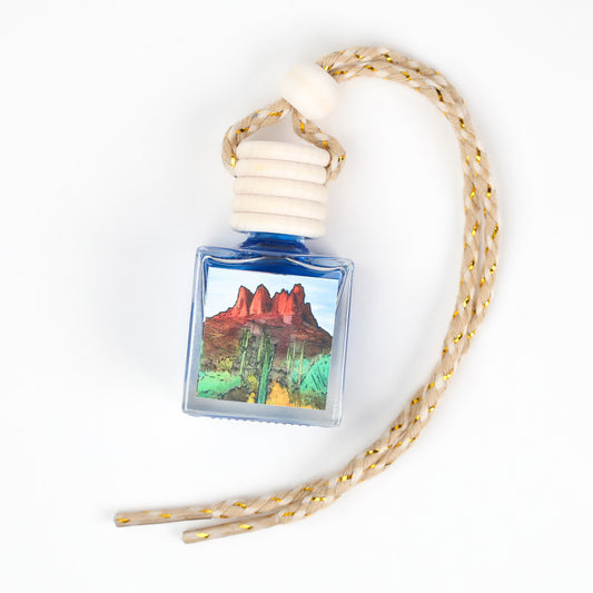 Blue car air freshener bottle with scenic cactus artwork and braided rope, perfect for home and vehicle.