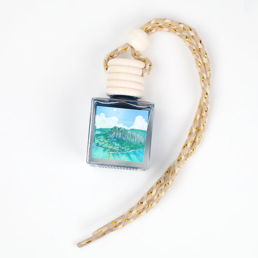 Blue glass air freshener with nature artwork, wooden stopper, and braided cord for hanging.