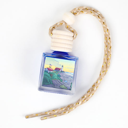 Blue glass fragrance bottle with lighthouse design and braided rope hanger for home decor.