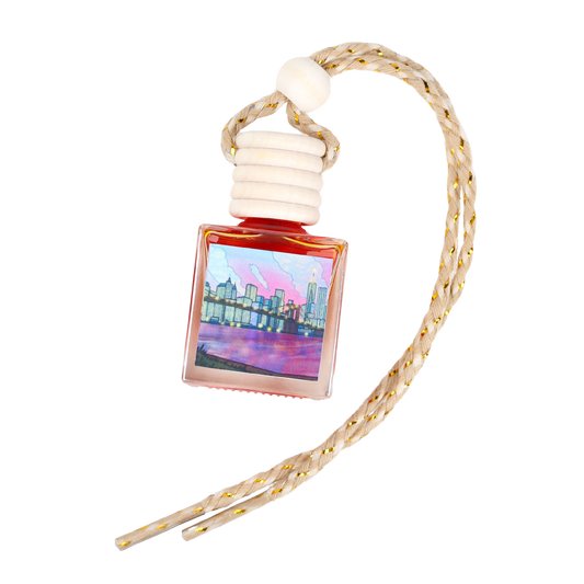 Artistic city skyline car air freshener in a pink glass bottle with a braided cord.