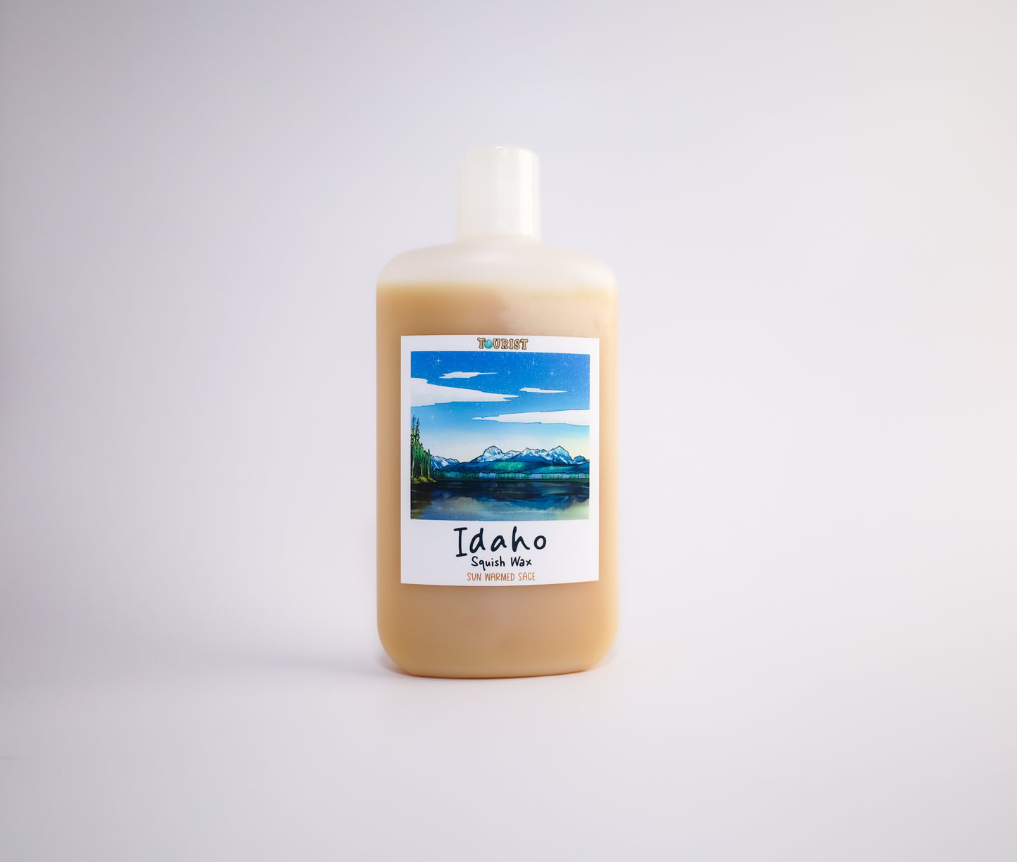 Bottle of Idaho squish wax with a scenic label on a white background