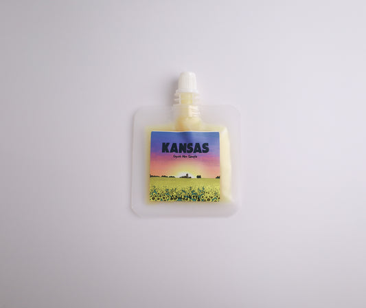 Small pouch with a colorful label featuring a landscape and the word 'Kansas' on a light gray background.