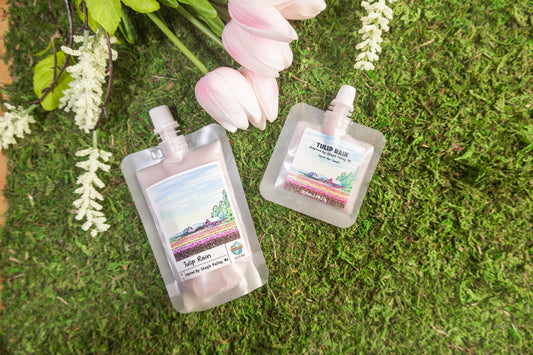 Two small pouches with labels on a green moss background with flowers.