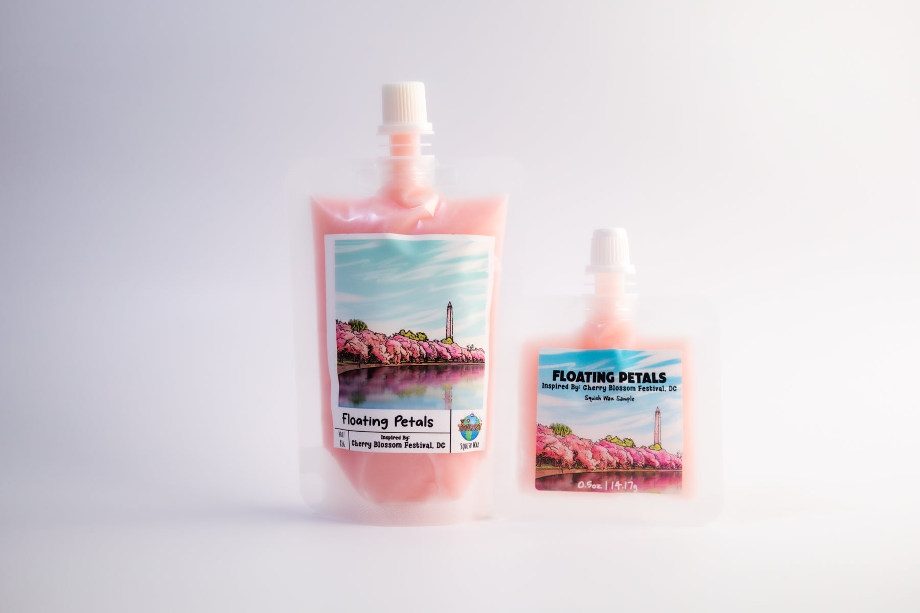 Two bottles of 'Floating Petals' product with cherry blossom imagery on a light gray background