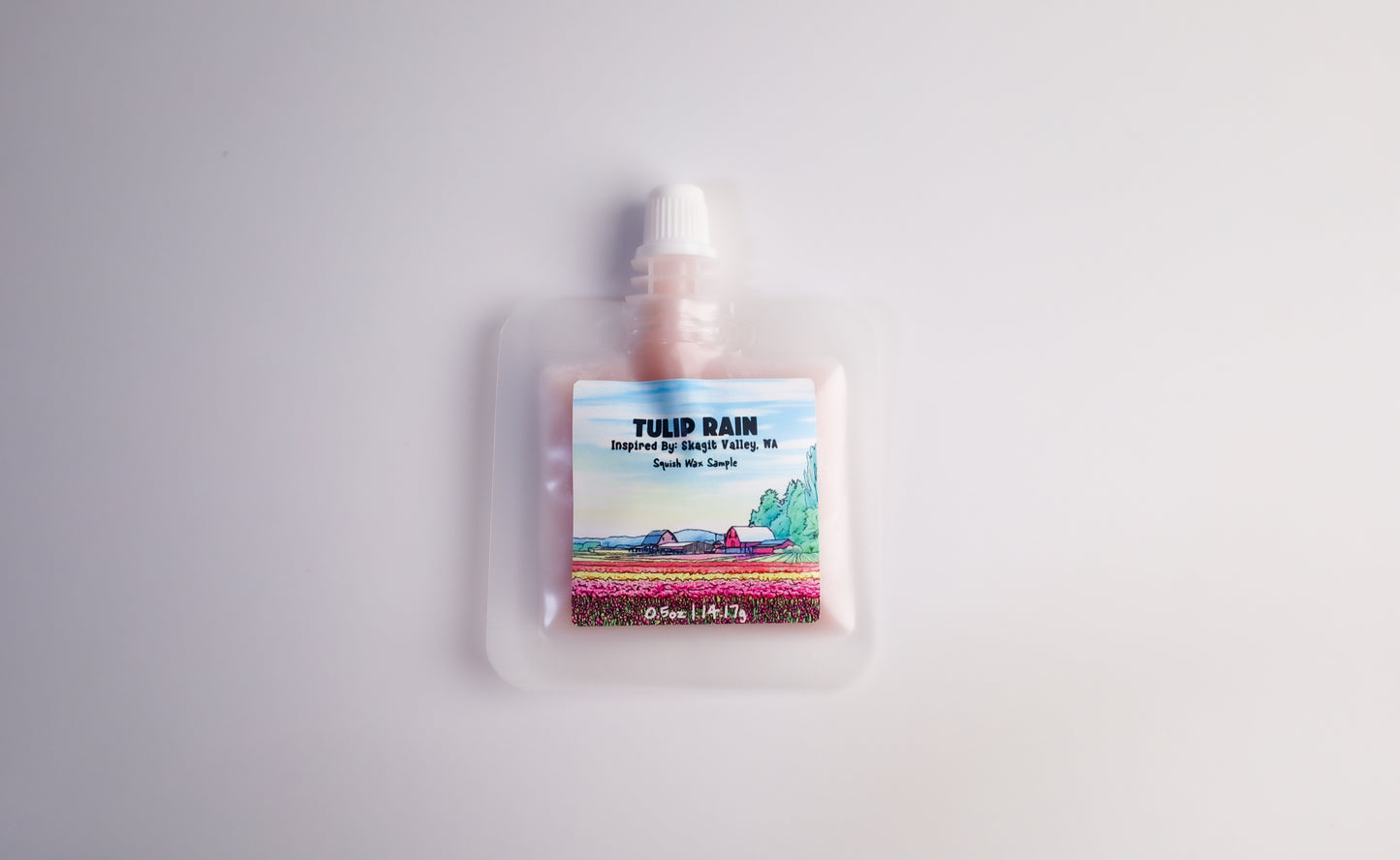 Pouch of tulip-themed squeezable wax melt product with a scenic label on a white background