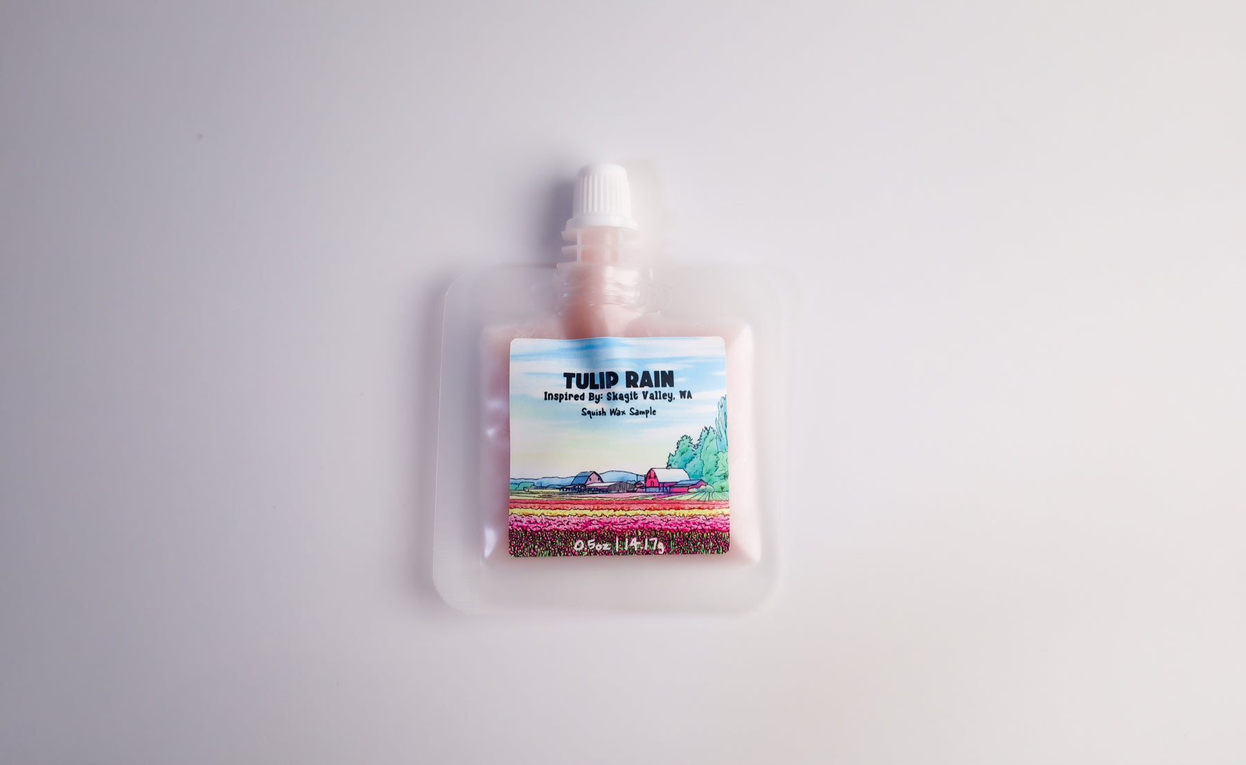 Pouch of tulip-themed squeezable wax melt product with a scenic label on a white background
