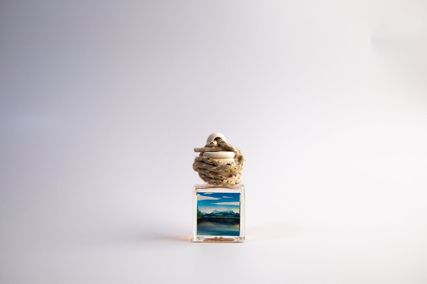 Small glass car freshener with Idaho themed artwork on white background