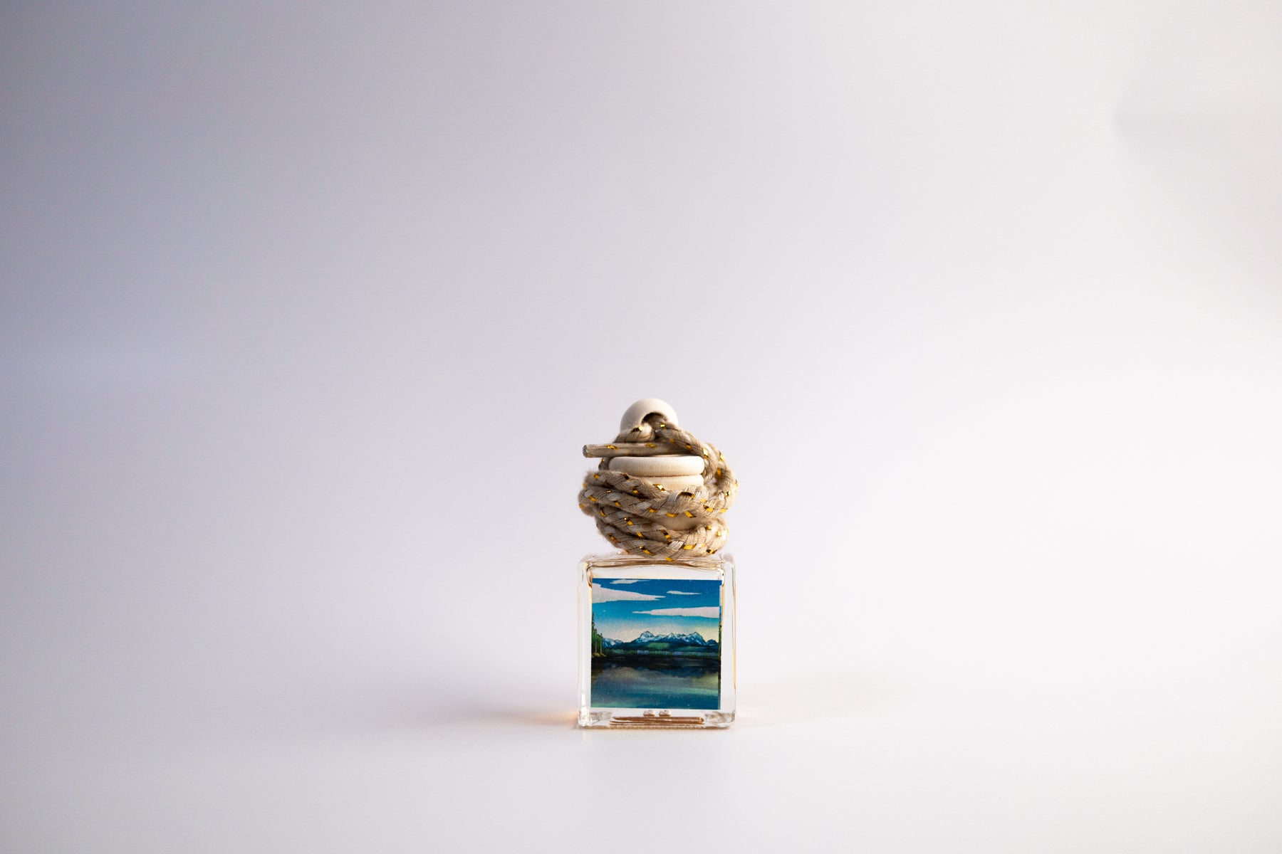 Small glass car freshener with Idaho themed artwork on white background