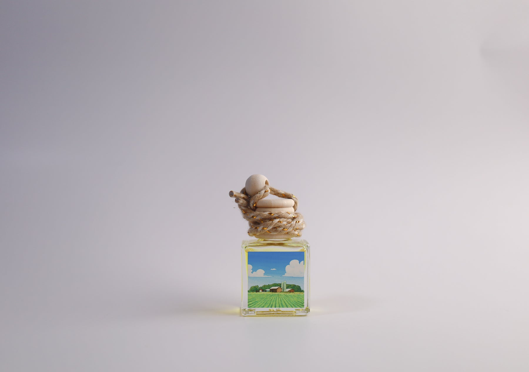 Small glass car freshener with Iowa themed artwork on white background