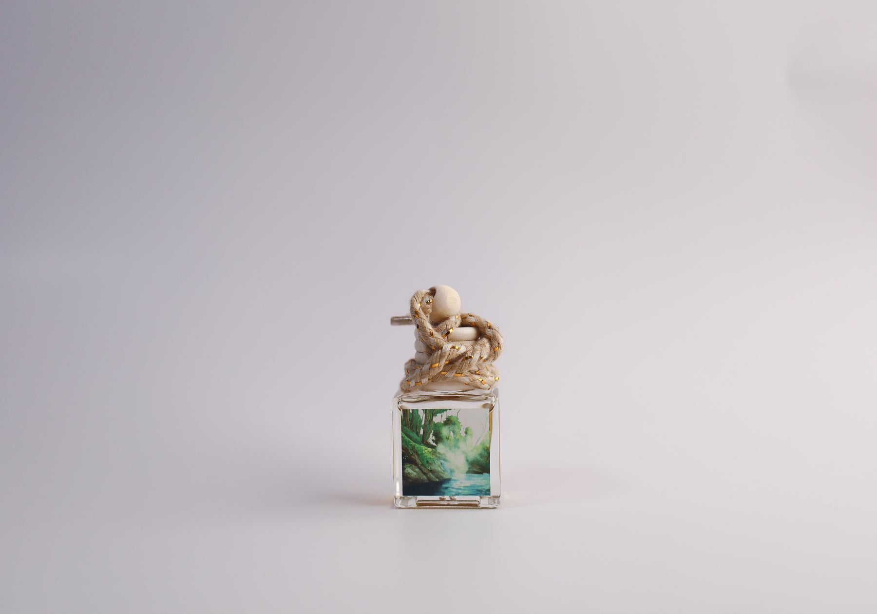 Small glass car freshener with Arkansas themed artwork on white background
