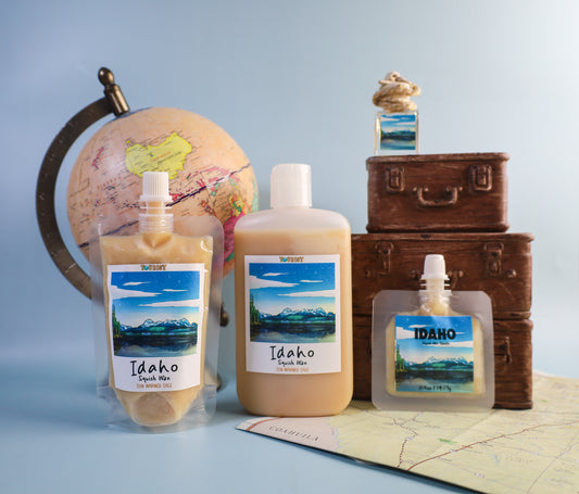 Three sizes of Idaho-themed squeezable wax melt product on a map with a globe and suitcases in the background.