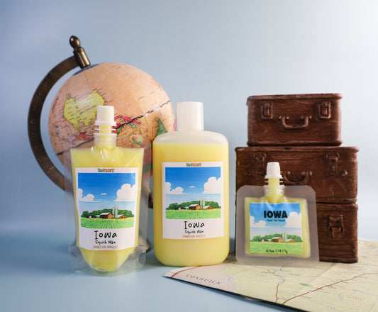 Three sizes of squish wax Iowa-themed product with a globe and suitcases in the background