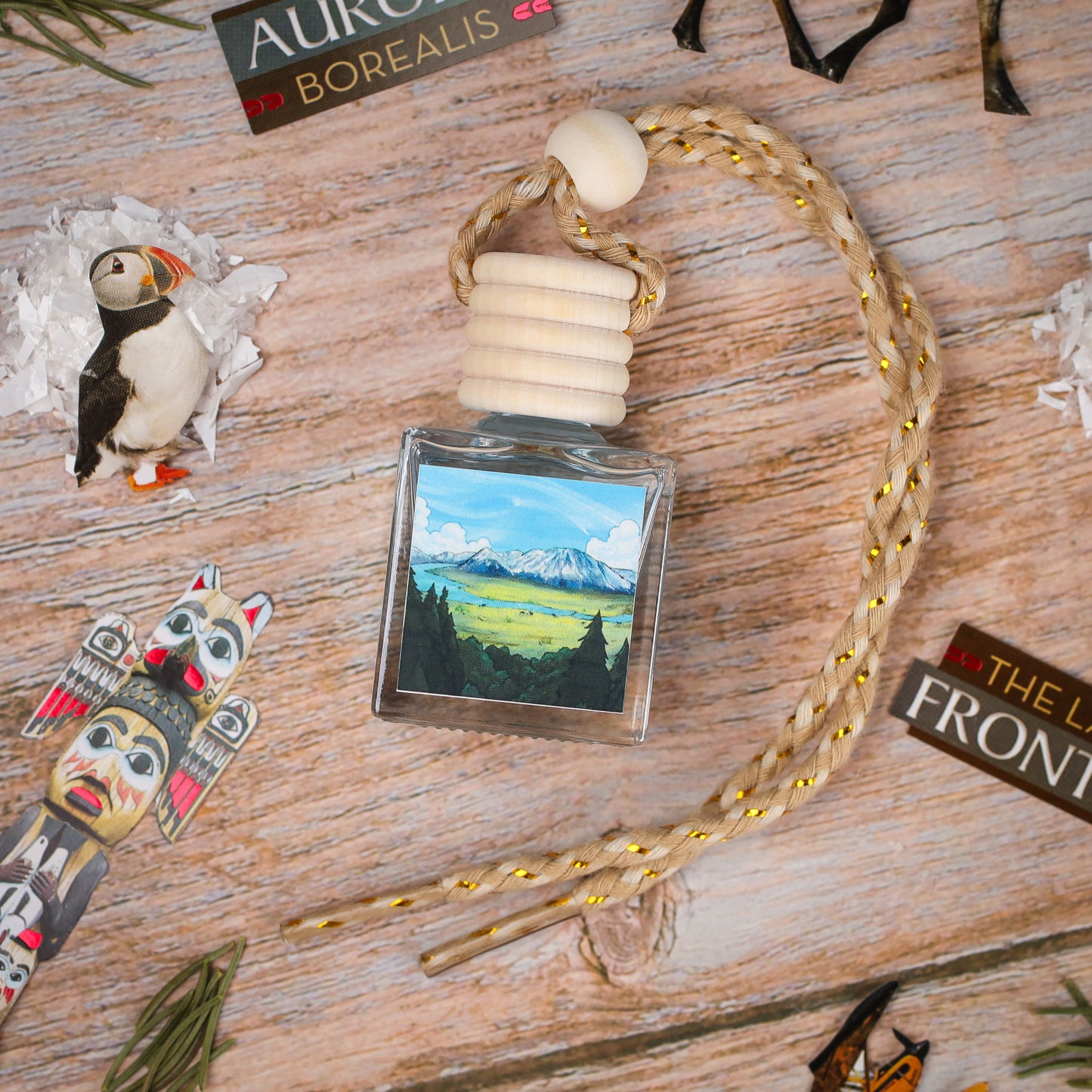 Artistic glass air freshener with nature scene, braided rope, and wooden accents, ideal for home decor.