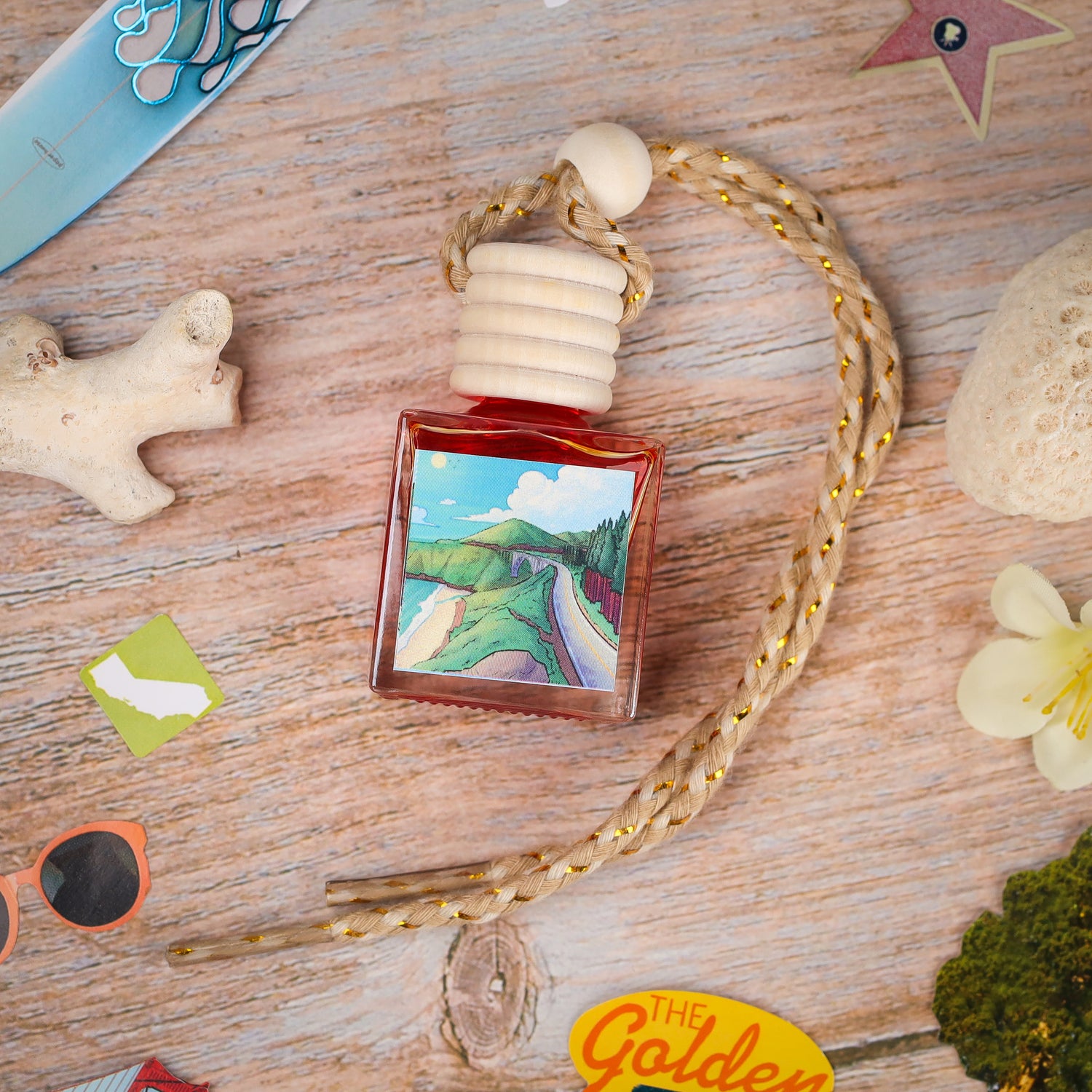 Colorful glass perfume bottle with a wooden cap, featuring a scenic landscape label and a braided rope.