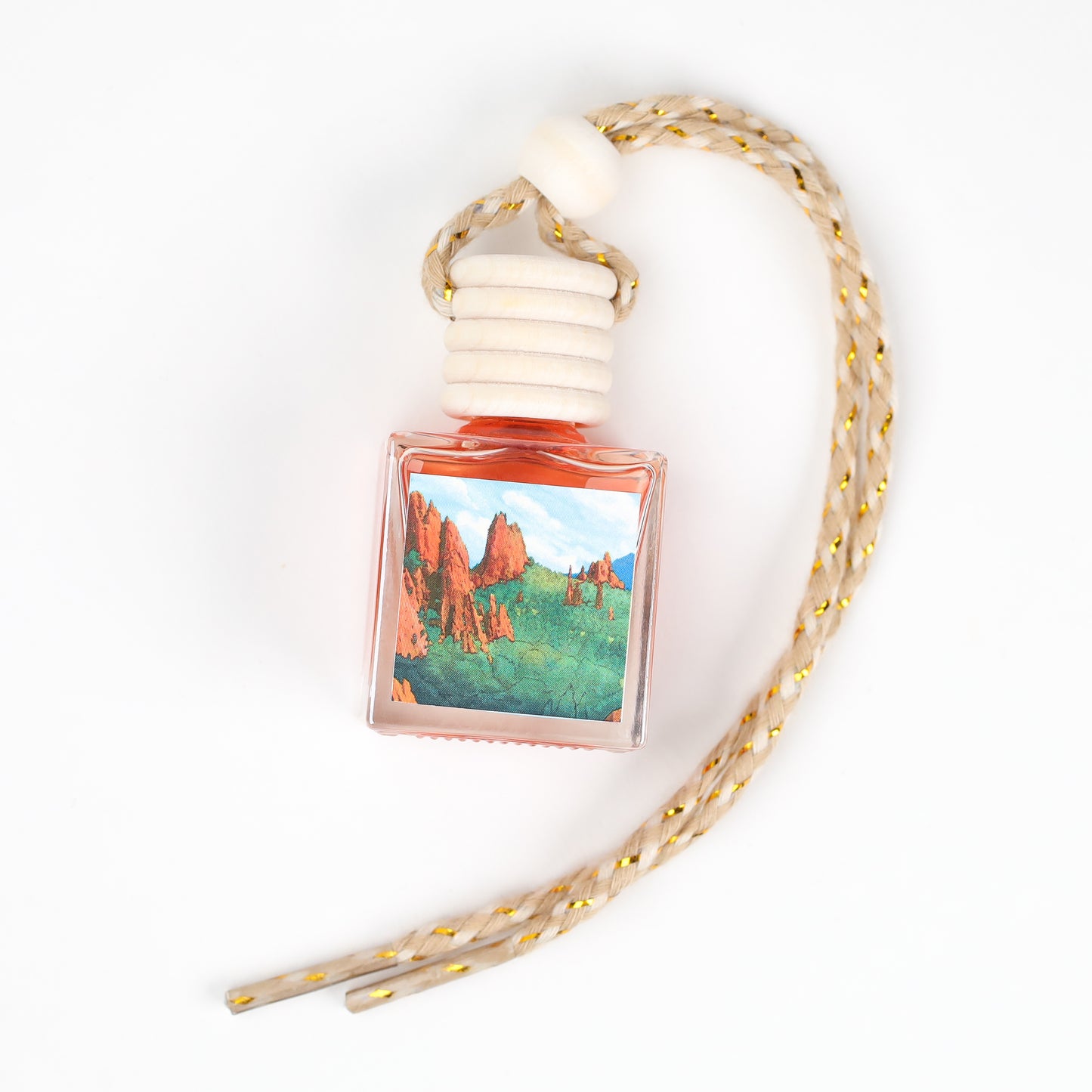 Artistic air freshener bottle with a colorful landscape design, featuring a braided rope for hanging.