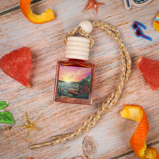 Sunset-inspired fragrance bottle with a wooden cap, featuring a vibrant landscape design.