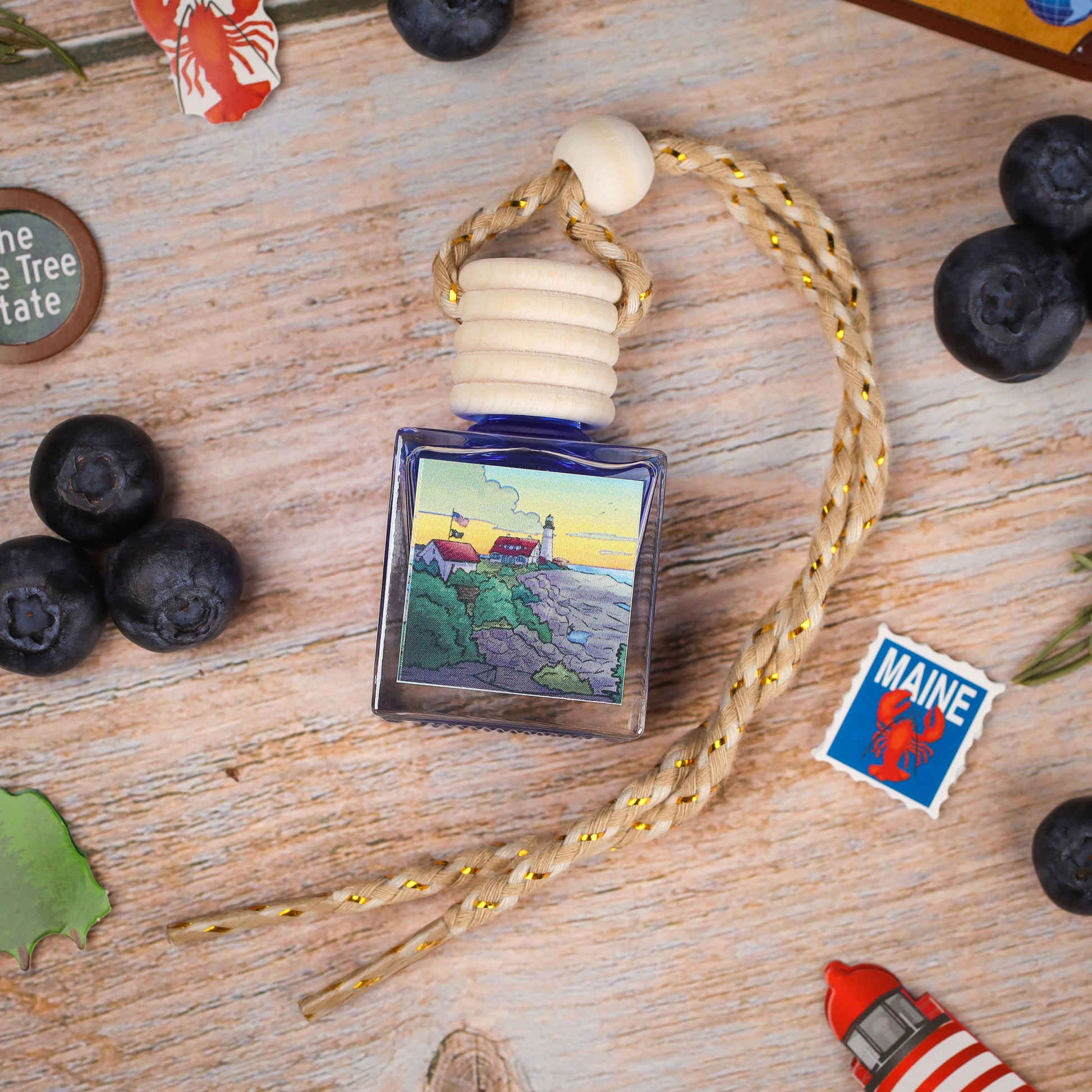 Blue glass perfume bottle with lighthouse design and braided rope, ideal for coastal decor.