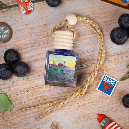 Blue glass perfume bottle with lighthouse design and braided rope, ideal for coastal decor.