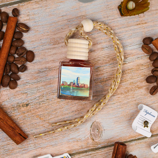 Scented car air freshener, amber color, decorative cityscape design, with wooden cap and braided rope.
