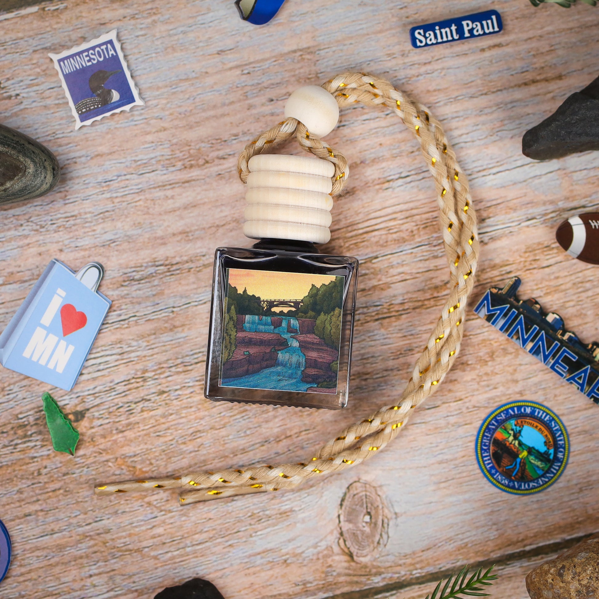 Minnesota waterfall fragrance diffuser, glass bottle with scenic artwork, natural wood cap, braided rope.