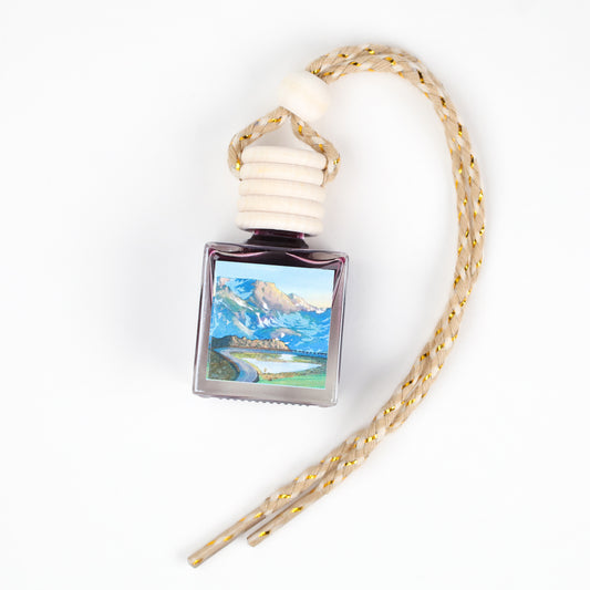 Purple air freshener bottle with scenic label and braided rope hanging strap.