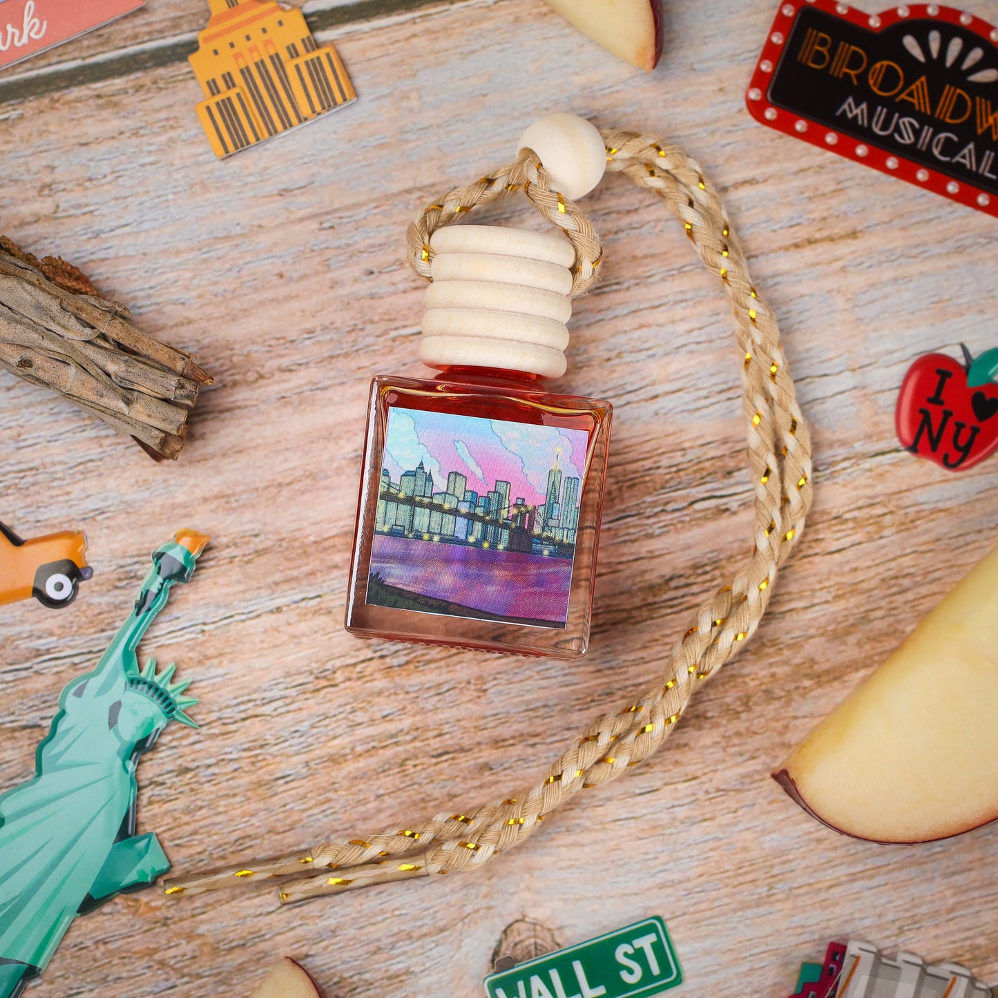 A stylish glass fragrance bottle with scenic city skyline label, featuring a braided rope and wooden cap.
