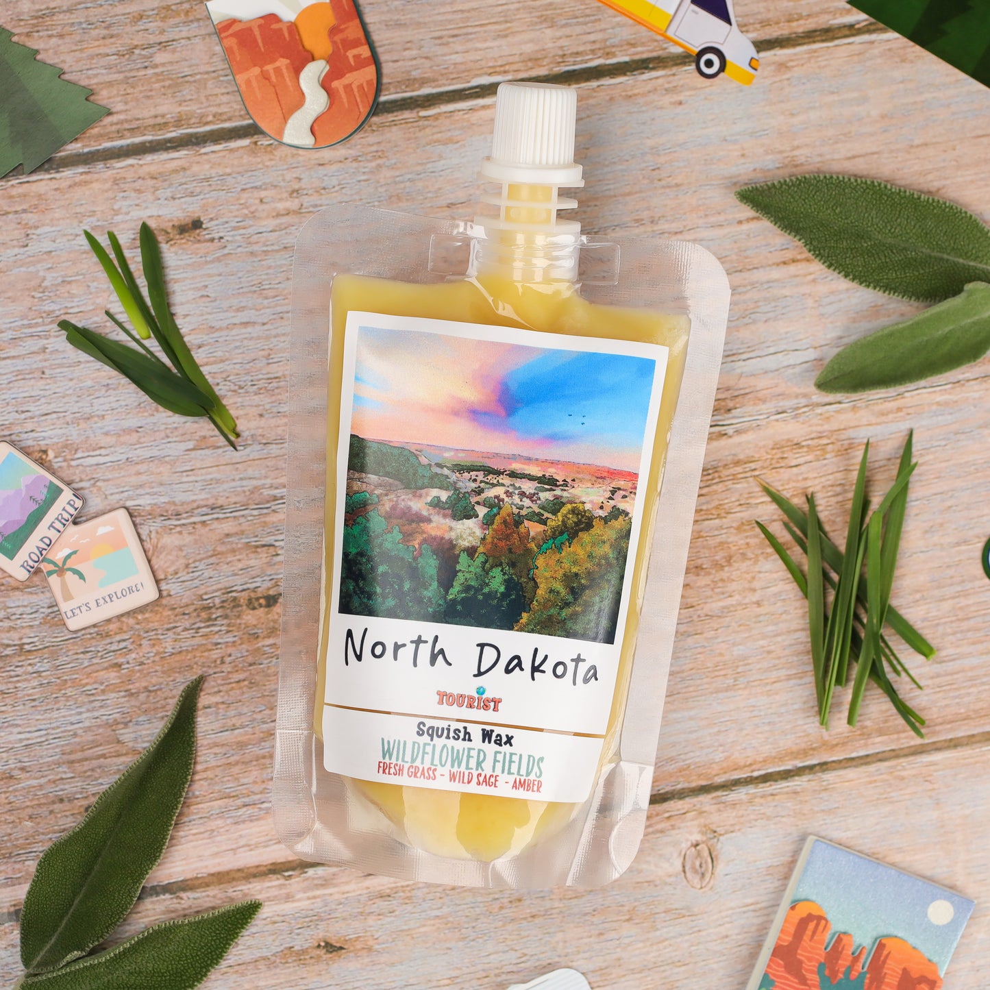 North Dakota Squish Wax in Wildflower Fields scent, yellow wax pouch with vibrant landscape design.